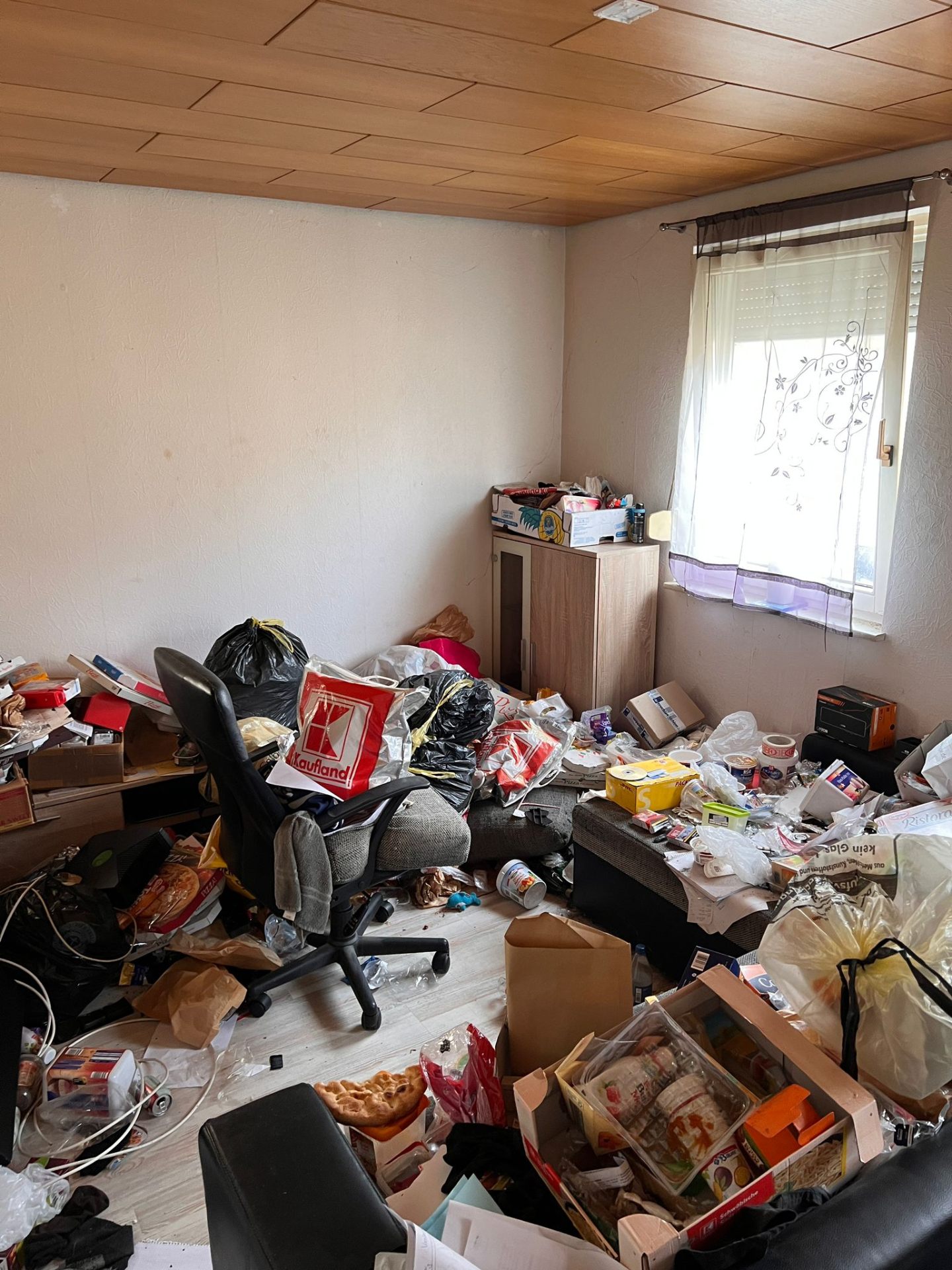 Wohnzimmer mit Stuhl, vollgestellt mit losem Hausrat