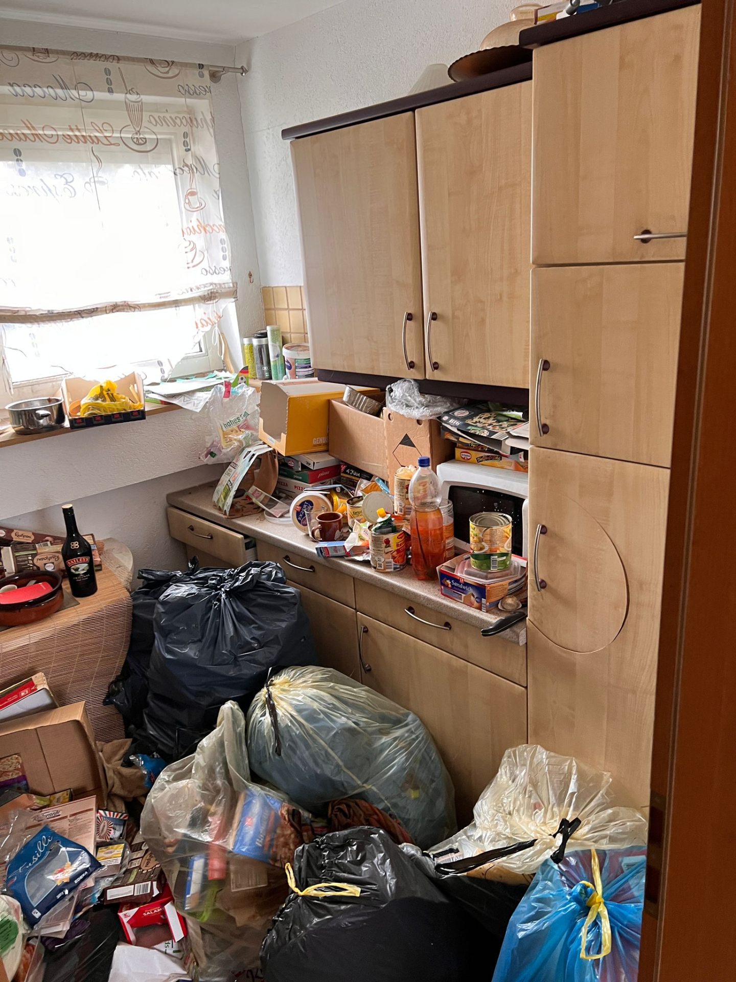 Stark vermüllte Küche mit Geschirr- und Hausratbergen
